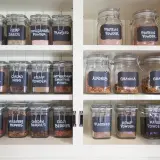 Un'elegante dispensa con barattoli di vetro etichettati a mano, un perfetto porta spezie fai da te per ingredienti salutari.