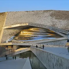 Un'iconica architettura contemporanea a Parigi, con una facciata metallica a scaglie e un nucleo dorato scintillante.