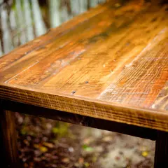Tavolo rustico con finitura ad olio di oliva su legno grezzo, che ne esalta le venature naturali e le imperfezioni.