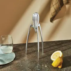 Spremiagrumi iconico di Philippe Starck, un bicchiere di succo e limoni freschi su un piano di lavoro.