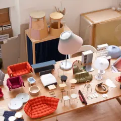 Modelli di mobili in miniatura, tessuti e materiali da artigianato disposti su un tavolo di legno. Un'ispirazione per creare, inga sempé.