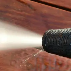 Ugello idropulitrice spruzza acqua su un deck in legno per eliminare odore vernice legno.