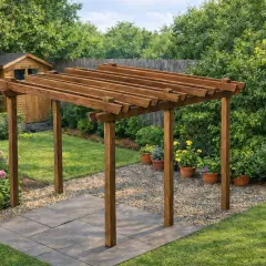 Un angolo di giardino con una pergola fai da te in legno, circondata da fiori rosa e verdi cespugli.