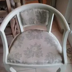 Vecchia poltrona in attesa di un restyling shabby chic. Tessuto floreale chiaro e struttura bianca da rinnovare.