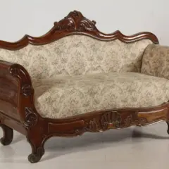 Divano in legno intagliato, con tessuto floreale, in **stile Luigi Filippo**. Un pezzo d'antiquariato che evoca eleganza.