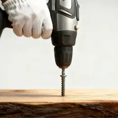 Mano guantata usa un trapano per avvitare una vite nel legno, mostrando come nascondere le viti nel legno per una finitura pulita.