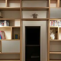Libreria in legno con libri, vasi e faretti. Un'idea per costruire una libreria funzionale e di design.