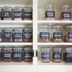 Un'elegante dispensa con barattoli di vetro etichettati a mano, un perfetto porta spezie fai da te per ingredienti salutari.