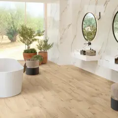 Bagno luminoso con vasca freestanding, piante verdi e specchi ovali. Un'oasi di relax in stile bohemien, con pavimenti in legno chiaro e dettagli in marmo.