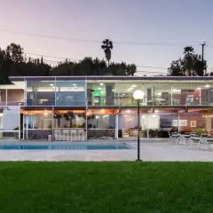 Villa moderna con piscina e scivolo, un esempio di architettura di Richard Neutra, con ampie vetrate che illuminano gli interni.
