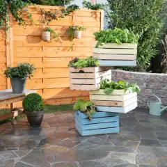 Fioriera fai da te con cassette di legno colorate impilate, piene di verdure fresche. Un'idea creativa per il tuo orto.