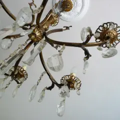 Un vecchio lampadario in ottone con pendenti di cristallo, un'idea per come riutilizzare un vecchio lampadario.