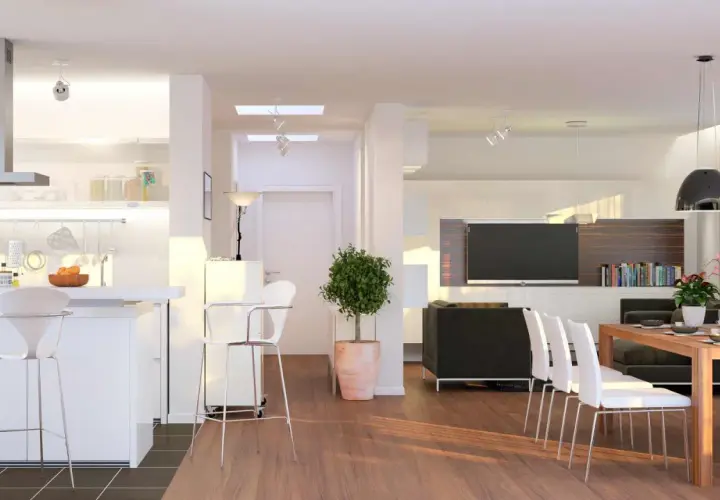 Ampio open space moderno con cucina, zona pranzo e soggiorno. Tavolo in legno con sedie bianche, divano nero, TV e libreria.