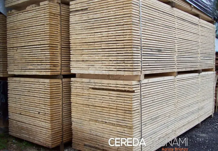 Pali di legno impilati, pronti per essere trasformati. Questo è il legno, materiale versatile e naturale.