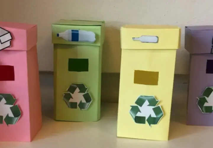 Quattro colorati contenitori per la raccolta differenziata fai da te, con simboli e immagini che indicano cosa gettare.