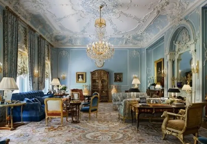 Salotto sontuoso in stile rococò, con soffitto decorato, lampadario di cristallo, tappeto persiano e mobili d'epoca.