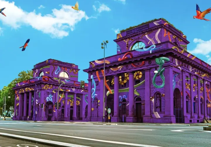 Edifici viola decorati con serpenti colorati e pappagalli volanti, un'installazione artistica che sembra un'opera fuori salone.
