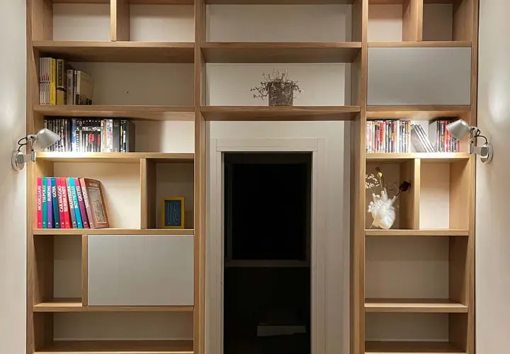 Libreria in legno con libri, vasi e faretti. Un'idea per costruire una libreria funzionale e di design.