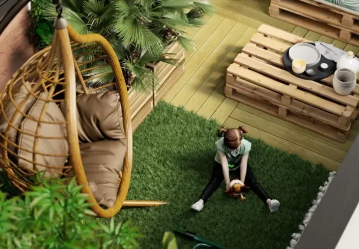 Bambina gioca su prato artificiale in un balcone con **giardini pensili**, sedia sospesa e tavolino fai-da-te.
