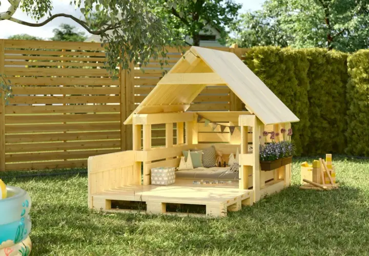 Casetta in legno fai-da-te, perfetta per giocare in giardino. Un'idea su come costruire una casetta in legno con pallet, con cuscini e giochi.