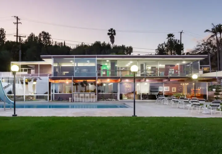 Villa moderna con piscina e scivolo, un esempio di architettura di Richard Neutra, con ampie vetrate che illuminano gli interni.