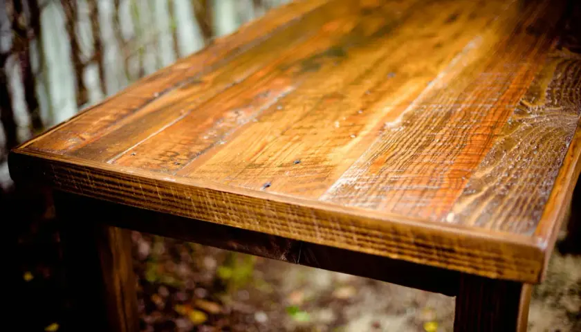 Tavolo rustico con finitura ad olio di oliva su legno grezzo, che ne esalta le venature naturali e le imperfezioni.
