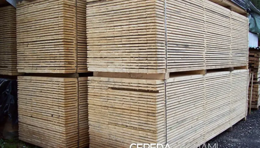 Pali di legno impilati, pronti per essere trasformati. Questo è il legno, materiale versatile e naturale.