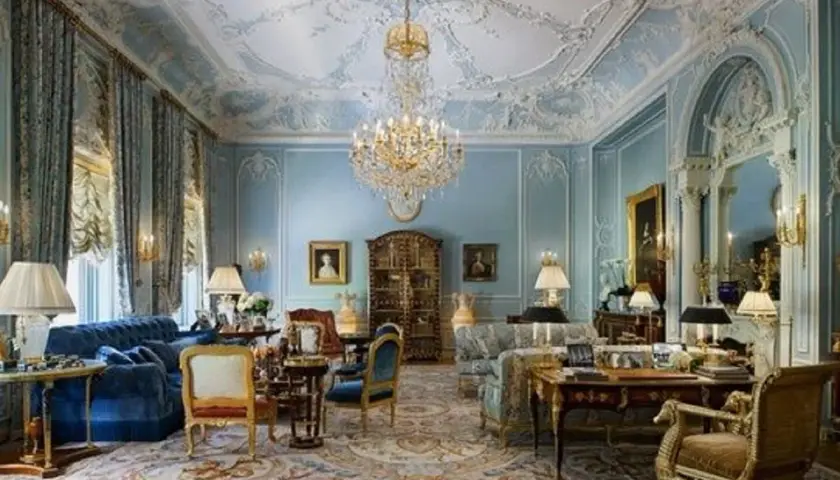 Salotto sontuoso in stile rococò, con soffitto decorato, lampadario di cristallo, tappeto persiano e mobili d'epoca.