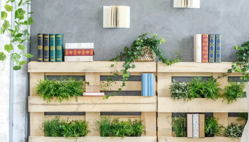 Scaffali in pallet con piante e libri, un'idea di bricolage per un angolo verde e letterario.