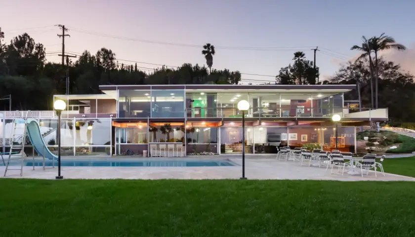 Villa moderna con piscina e scivolo, un esempio di architettura di Richard Neutra, con ampie vetrate che illuminano gli interni.