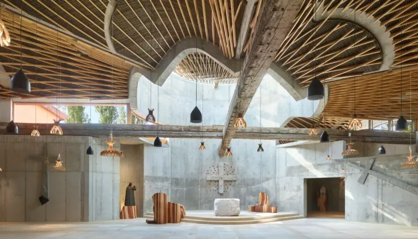 Interno di chiesa moderna con soffitto in legno e cemento, opera di Benedetta Tagliabue.