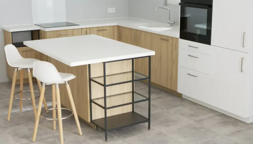 Un'elegante isola cucina fai da te con piano bianco e struttura metallica, perfetta per un angolo colazione.