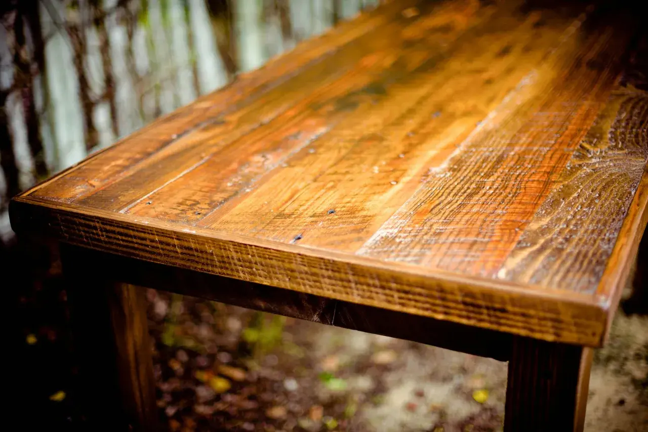 Tavolo rustico con finitura ad olio di oliva su legno grezzo, che ne esalta le venature naturali e le imperfezioni.