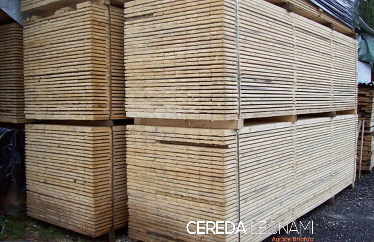 Pali di legno impilati, pronti per essere trasformati. Questo è il legno, materiale versatile e naturale.