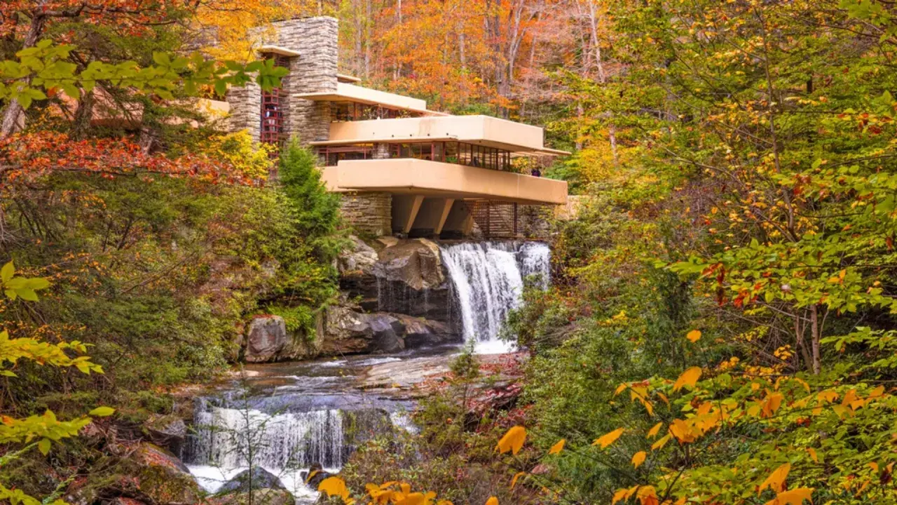 Casa sulla cascata, un capolavoro di architettura organica, si fonde con la natura autunnale e le acque impetuose.