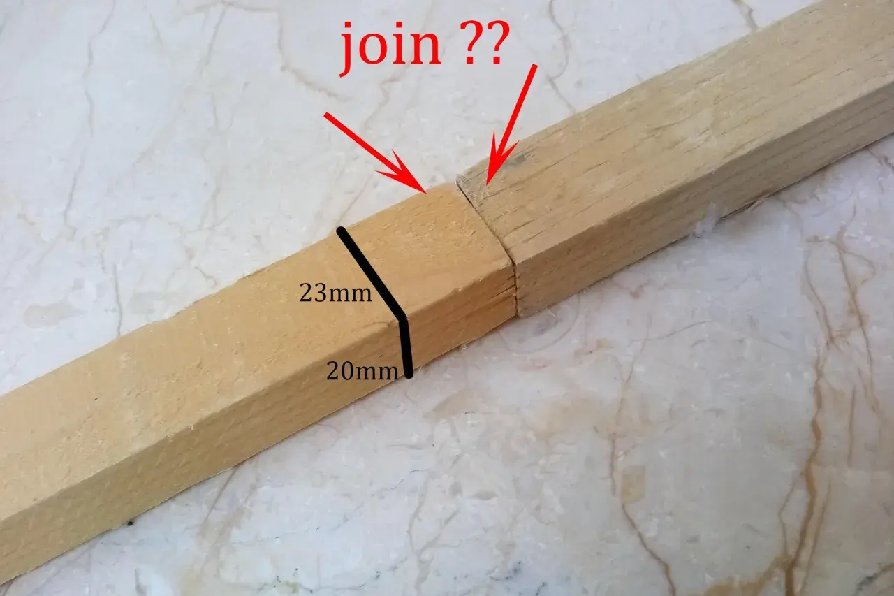 Due pezzi di legno con tagli obliqui, pronti per essere uniti. Le frecce rosse indicano il punto di giunzione.