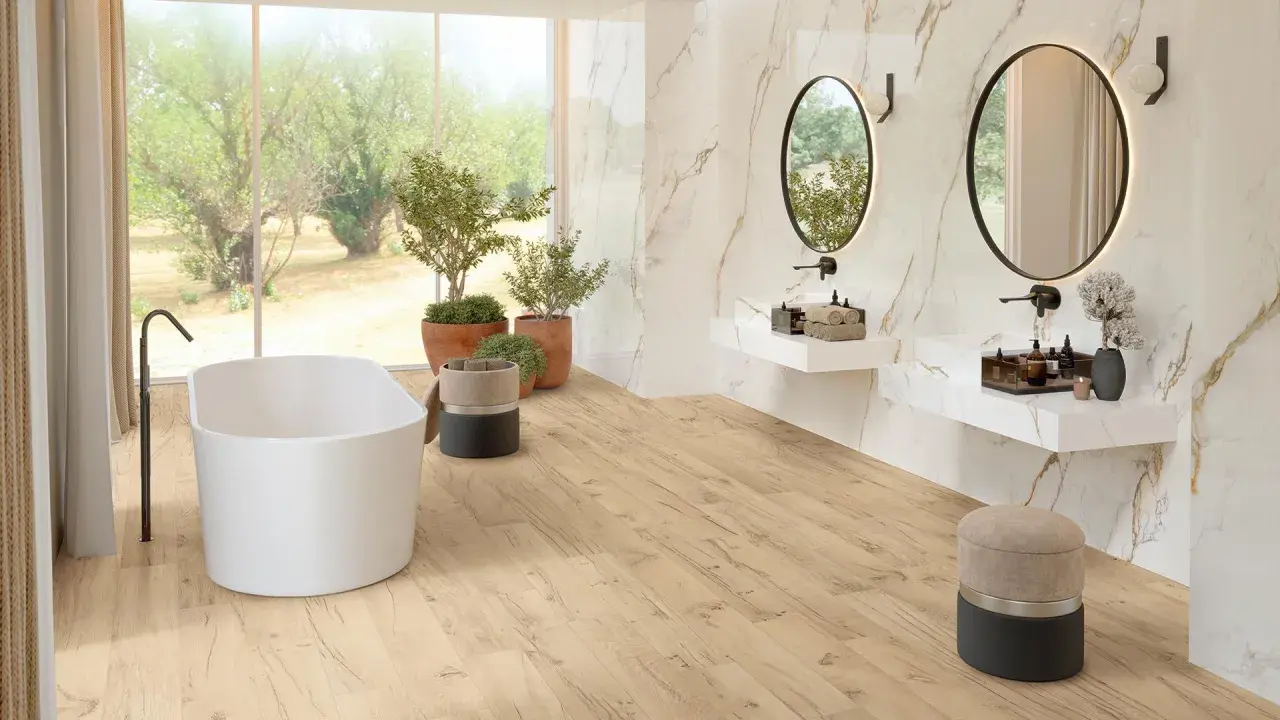 Bagno luminoso con vasca freestanding, piante verdi e specchi ovali. Un'oasi di relax in stile bohemien, con pavimenti in legno chiaro e dettagli in marmo.