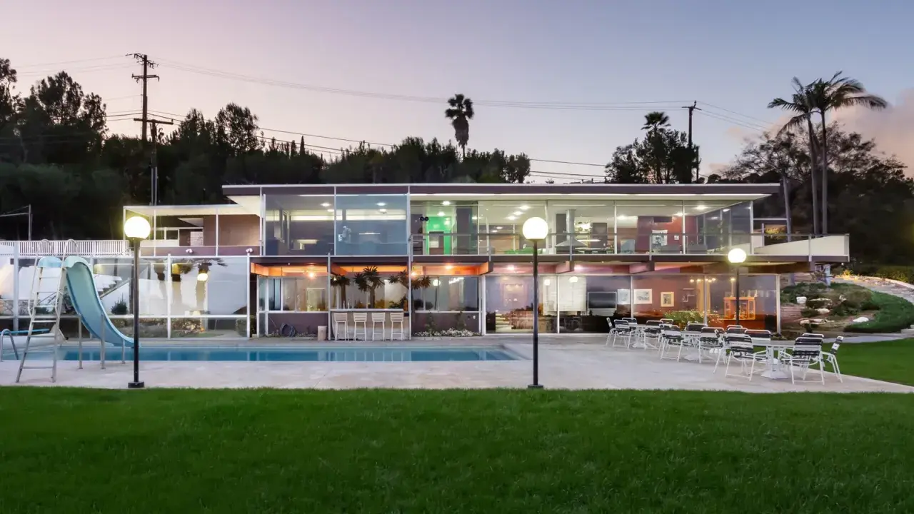 Villa moderna con piscina e scivolo, un esempio di architettura di Richard Neutra, con ampie vetrate che illuminano gli interni.
