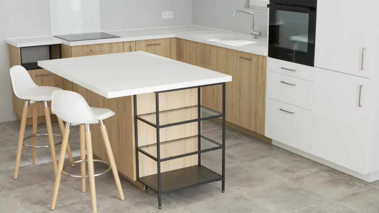Un'elegante isola cucina fai da te con piano bianco e struttura metallica, perfetta per un angolo colazione.