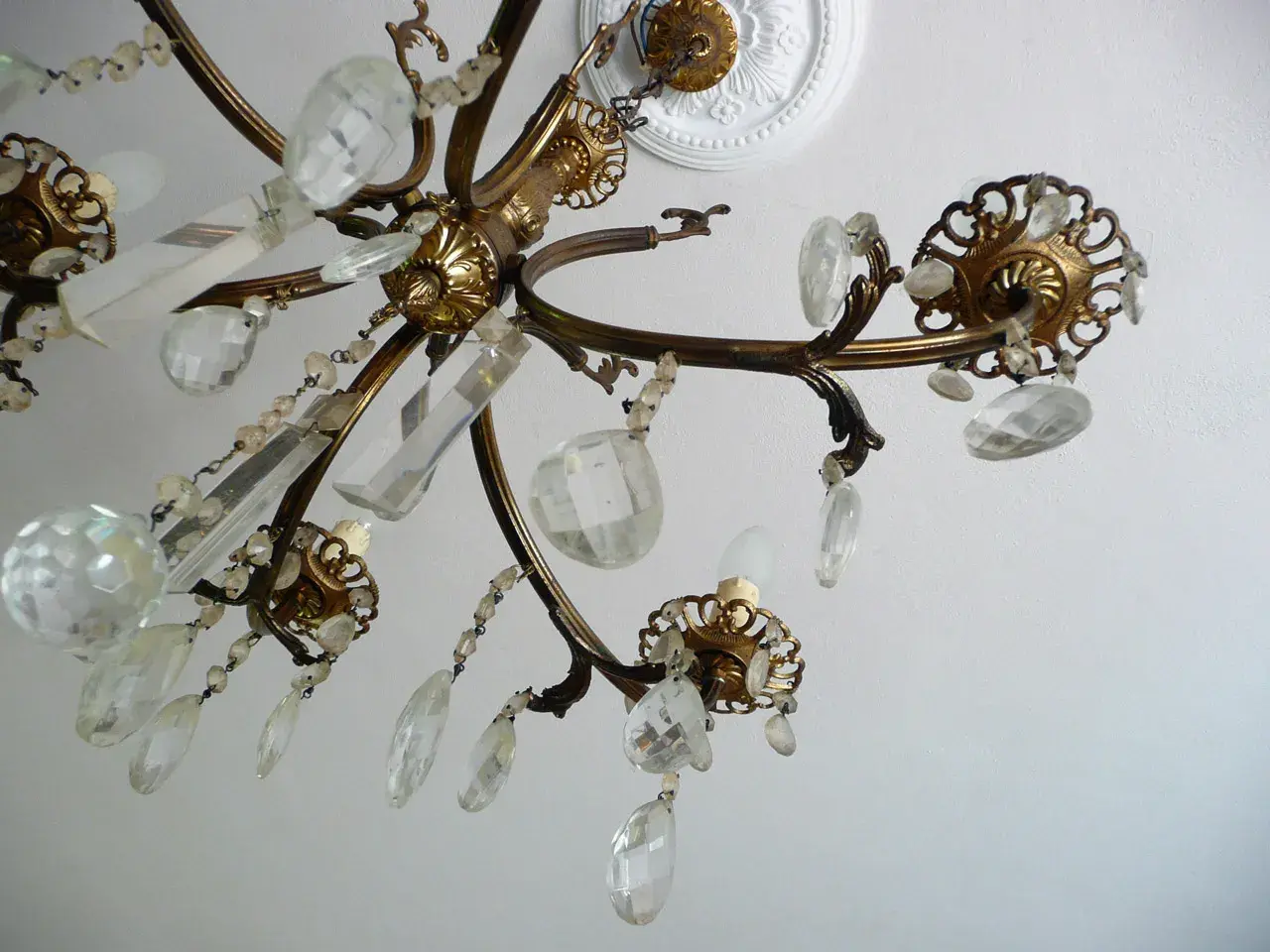 Un vecchio lampadario in ottone con pendenti di cristallo, un'idea per come riutilizzare un vecchio lampadario.