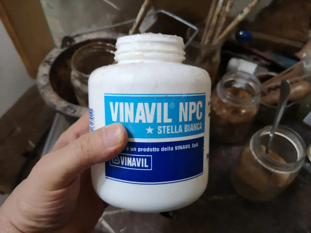 Mano che tiene un barattolo di Vinavil NPC Stella Bianca. Il tempo asciugatura vinavil &egrave; rapido, ideale per lavori creativi.