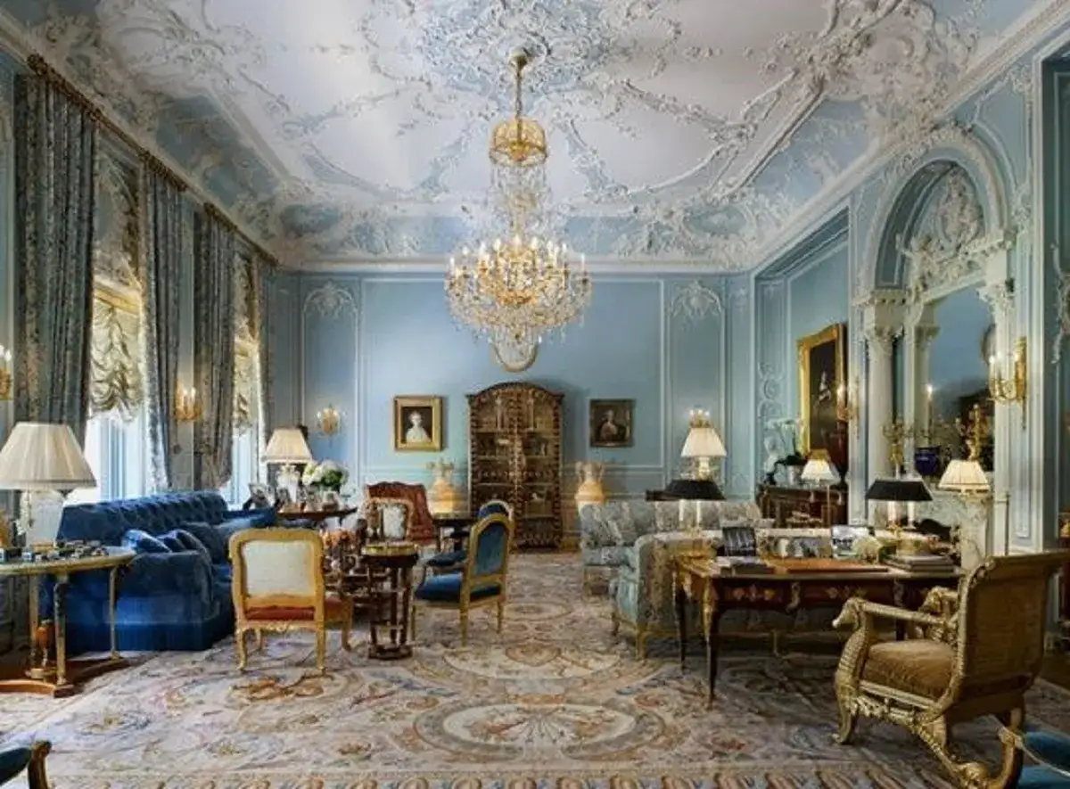 Salotto opulento in stile rococò, con soffitto decorato, lampadario di cristallo, tappeto persiano e mobili d'epoca.