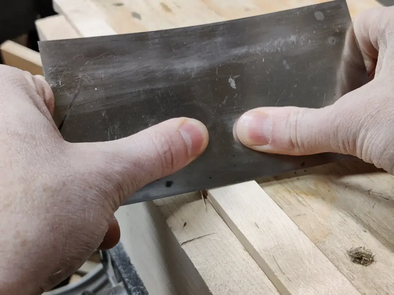 Mani esperte che usano una raspa per levigare il legno, mostrando come si lavora il legno con precisione e cura.