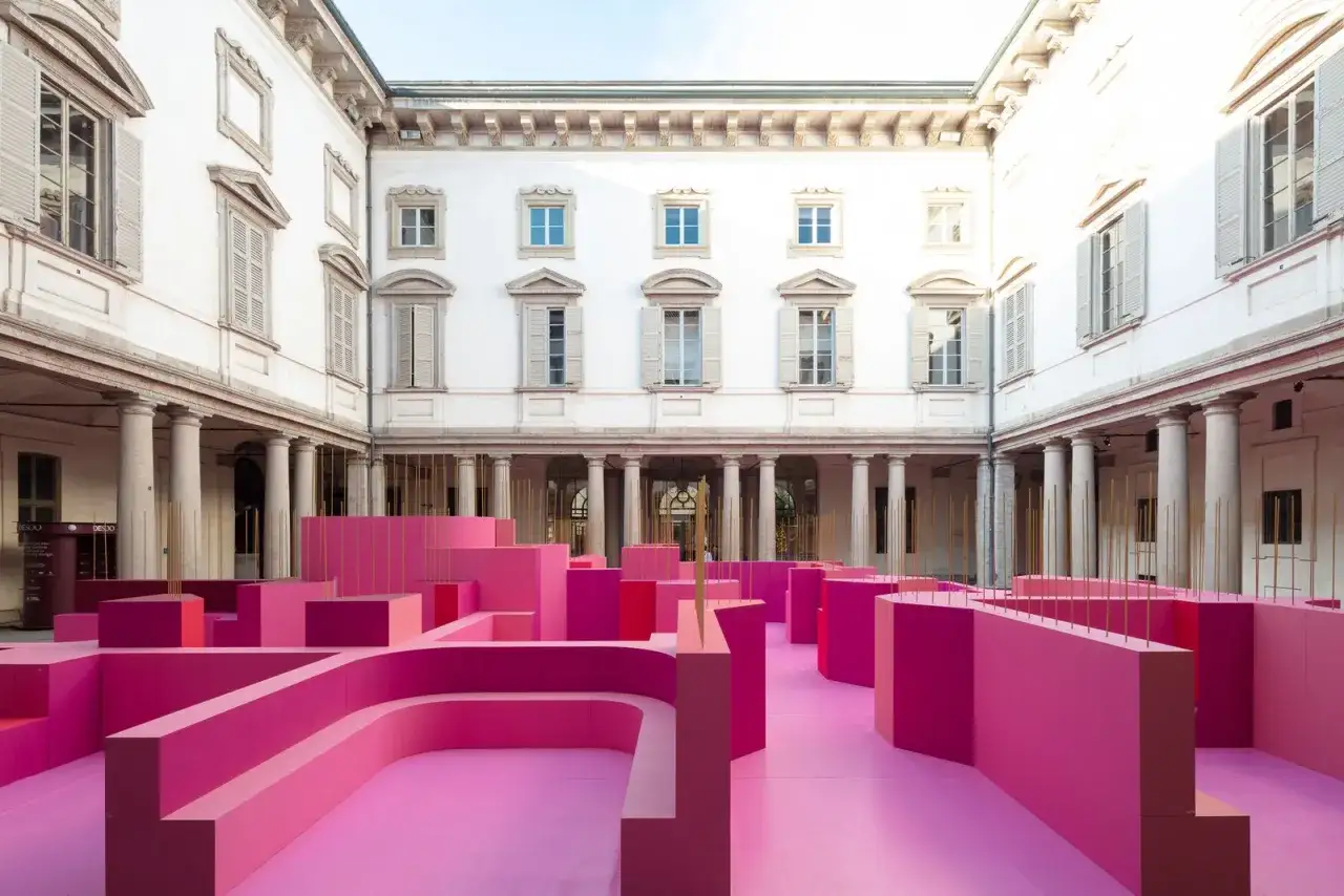 Installazione rosa shocking in un cortile storico, un'anticipazione audace della Design Week Milano 2026.