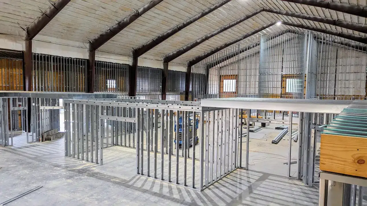Struttura metallica per creare una parete divisoria in un capannone industriale. L'intelaiatura è in fase di montaggio, pronta per essere rivestita.