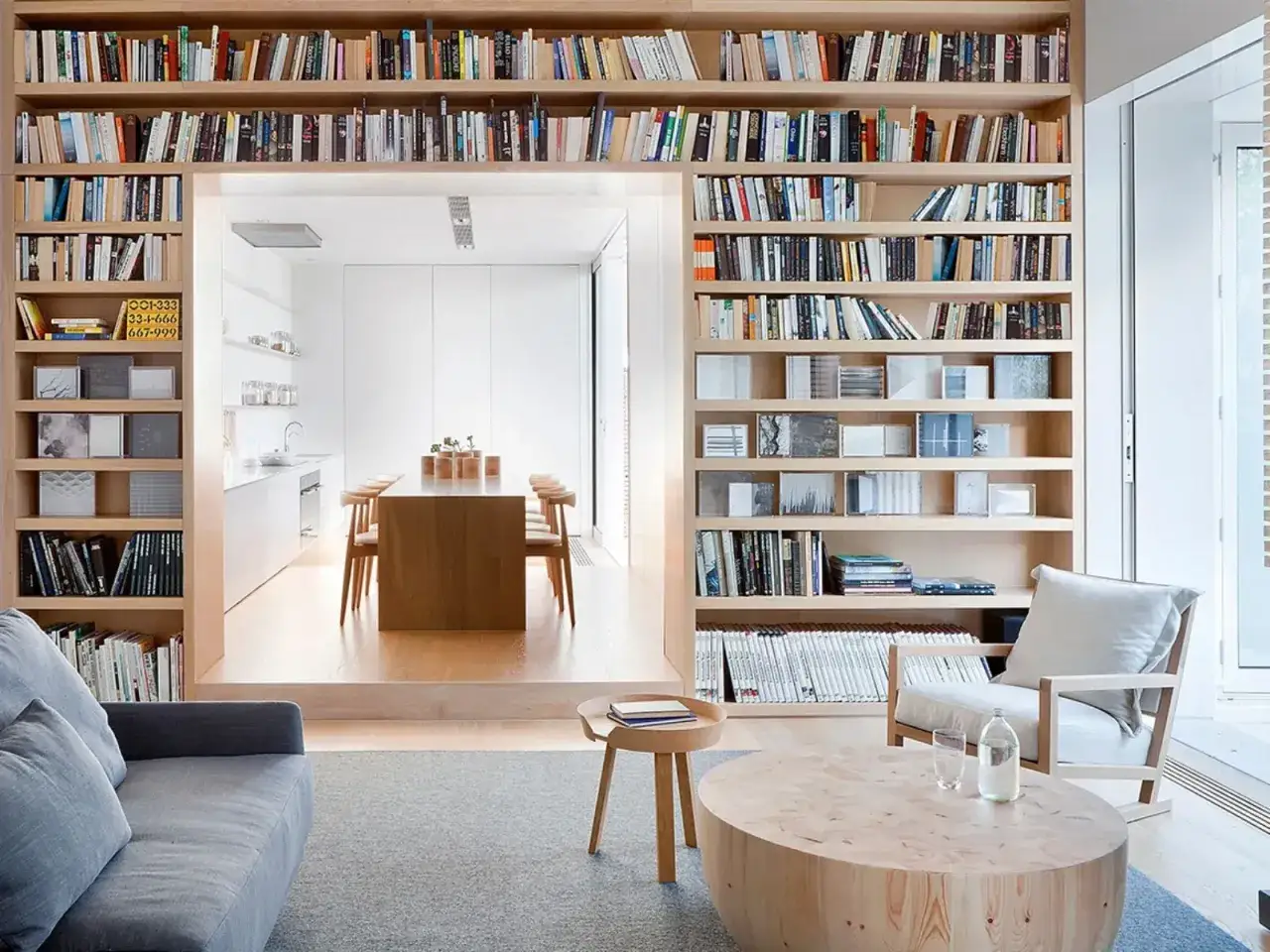 Un'ampia libreria in legno, perfetta per costruire una libreria dei sogni, domina la scena, piena di libri e oggetti.