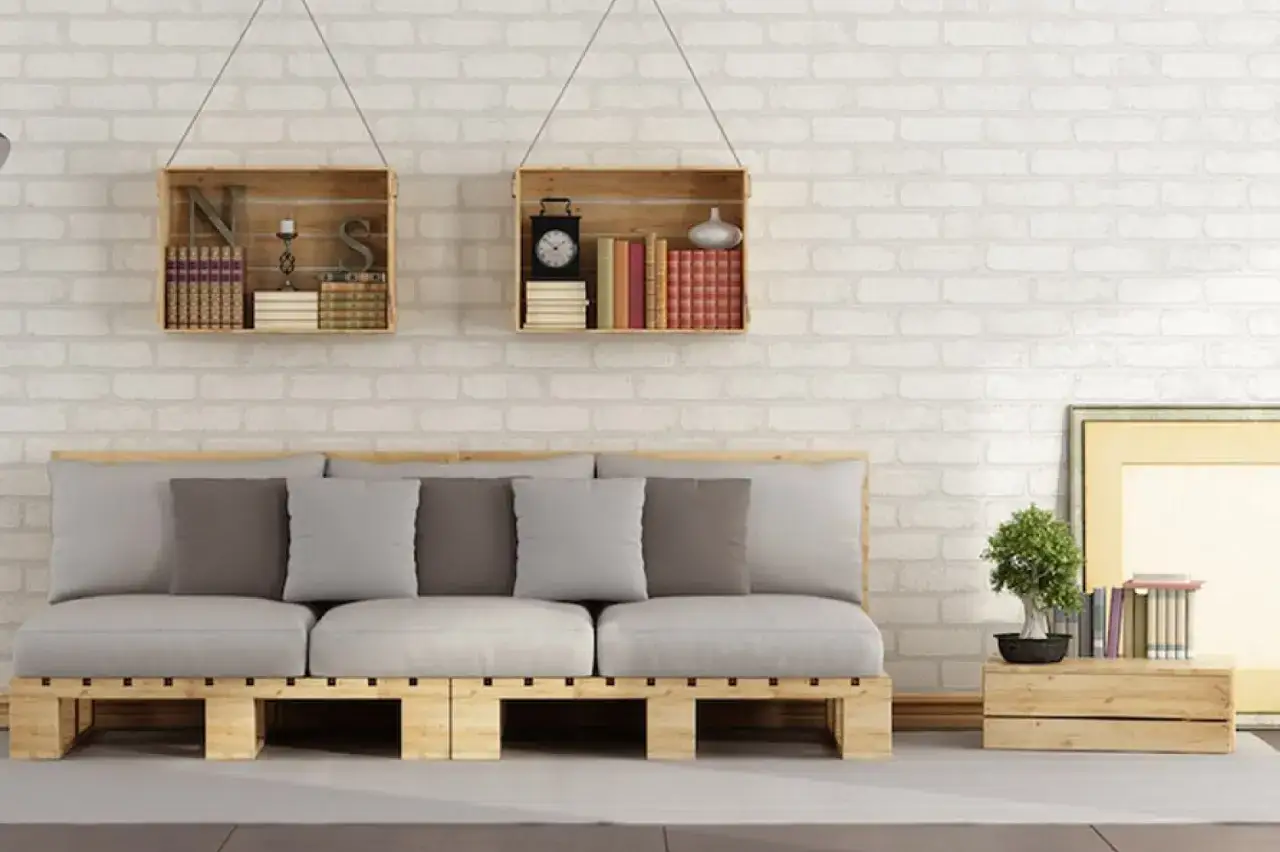 Divano in pallet e mensole fai da te facili, con libri e decorazioni.