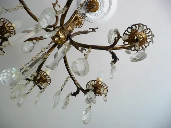 Un vecchio lampadario in ottone con pendenti di cristallo, un'idea per come riutilizzare un vecchio lampadario.